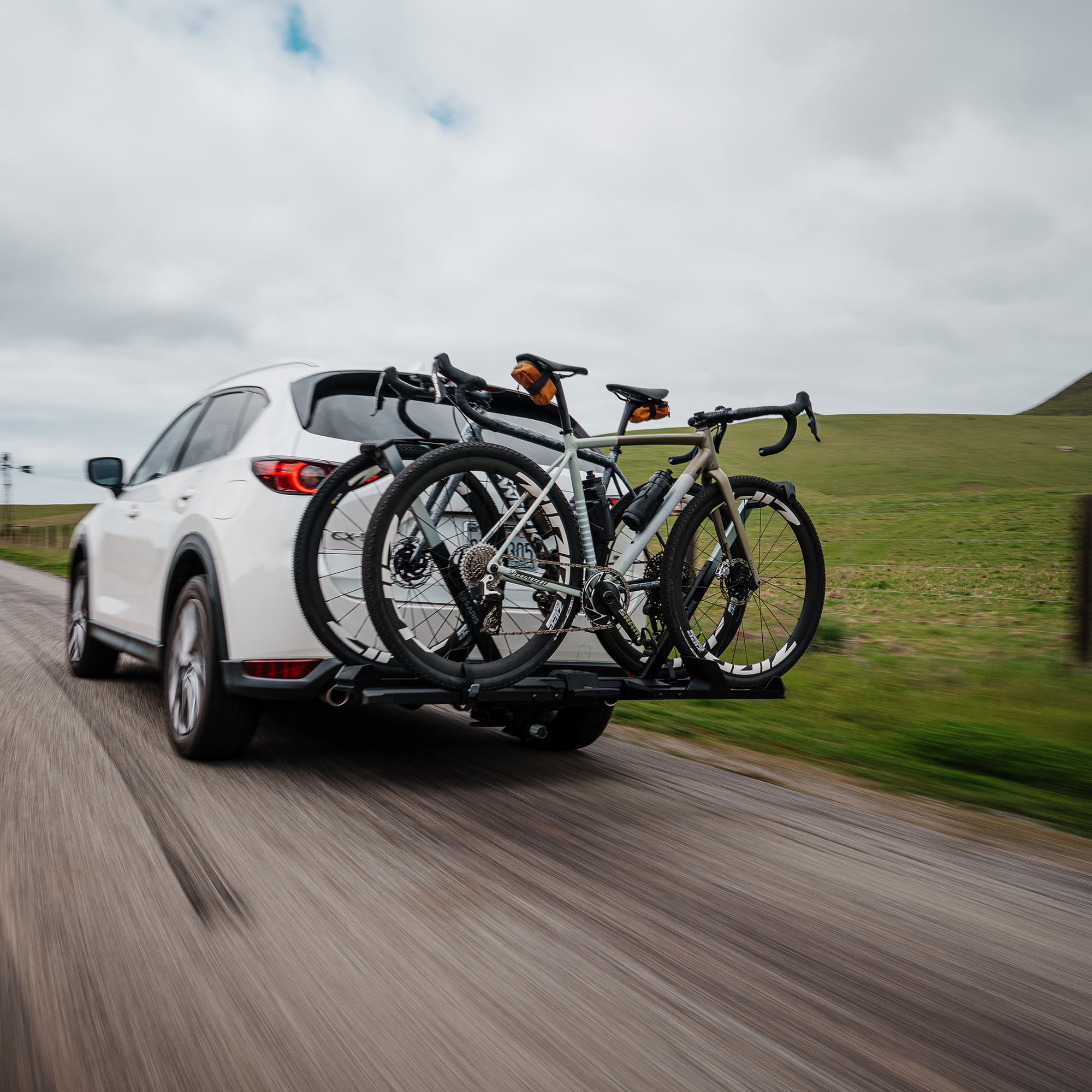 SuperClamp G4 on back of SUV loaded with bikes driving down the road